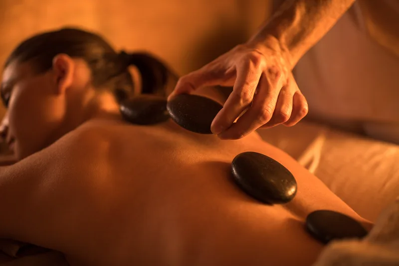 Hot stones being placed along a guest's back during a spa treatment